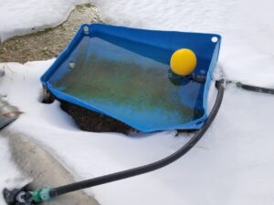 plastic, 55-gallon dairy soap barrel cut in half, with a commercial flow valve installed