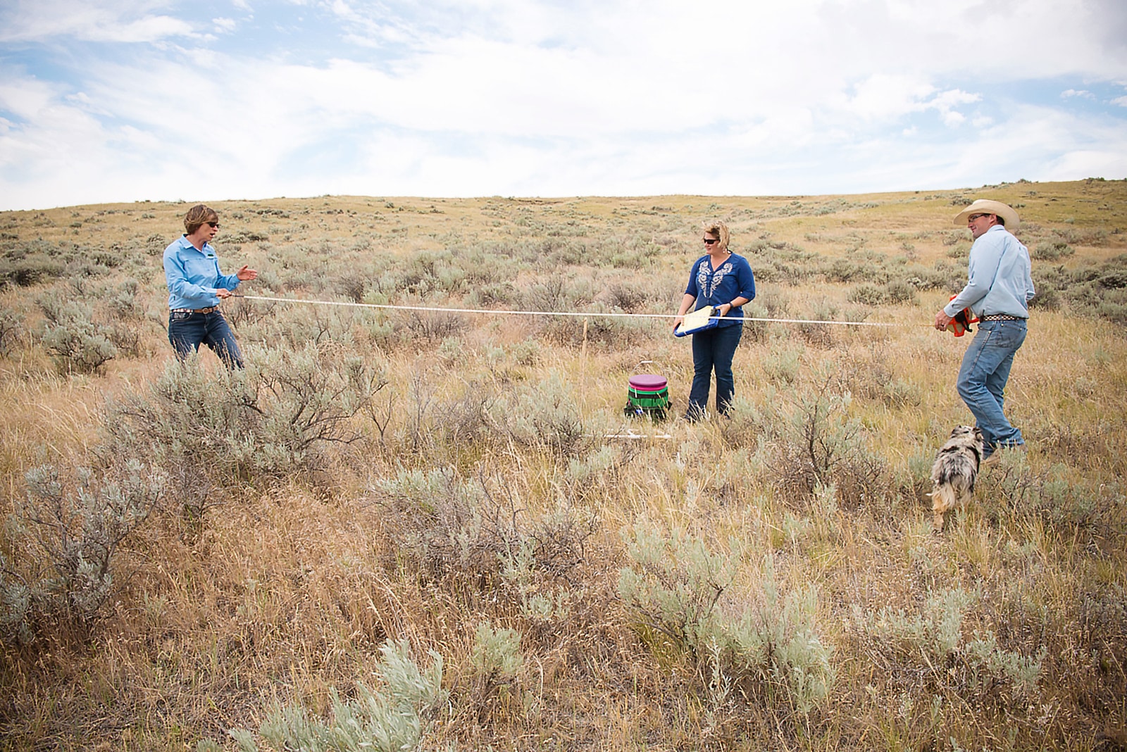 three people standing on rangeland