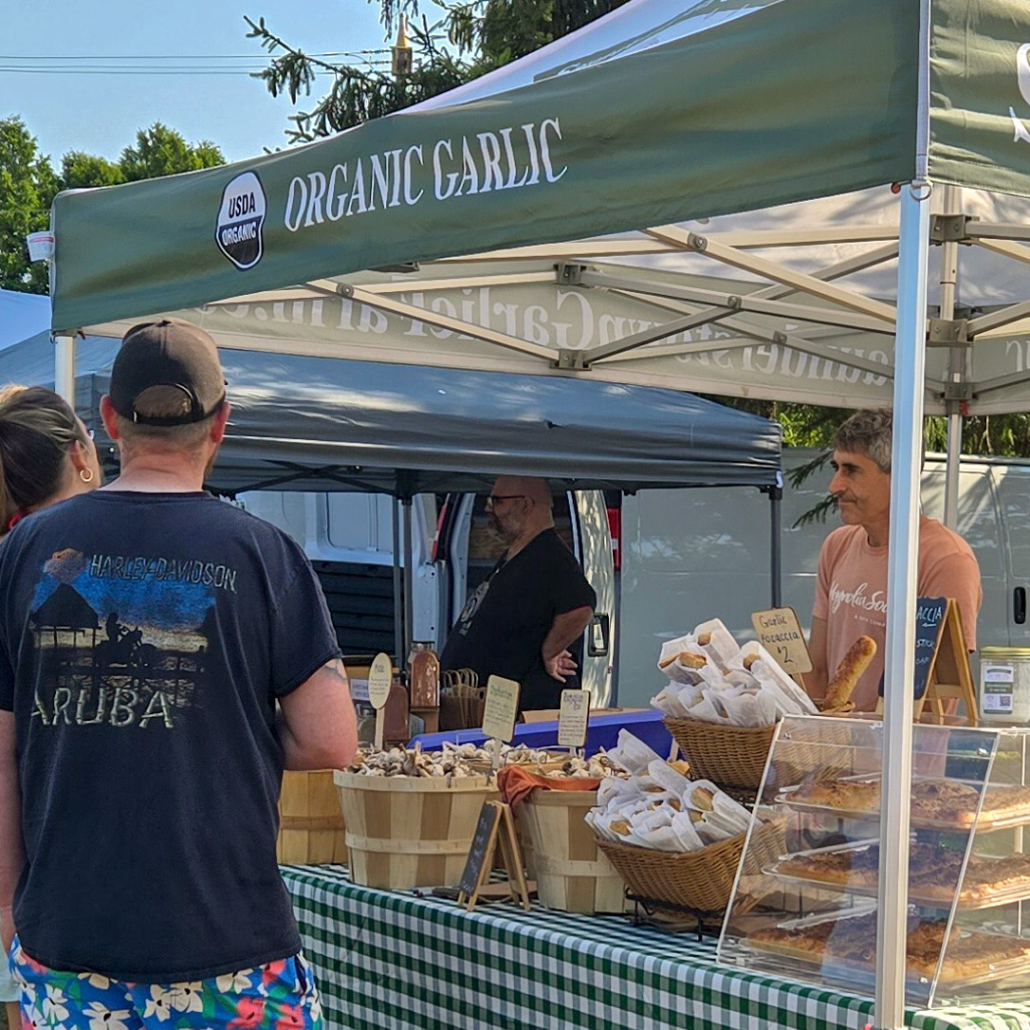 Farmers market booth sign with USDA Organic seal and text saying Organic Garlic.