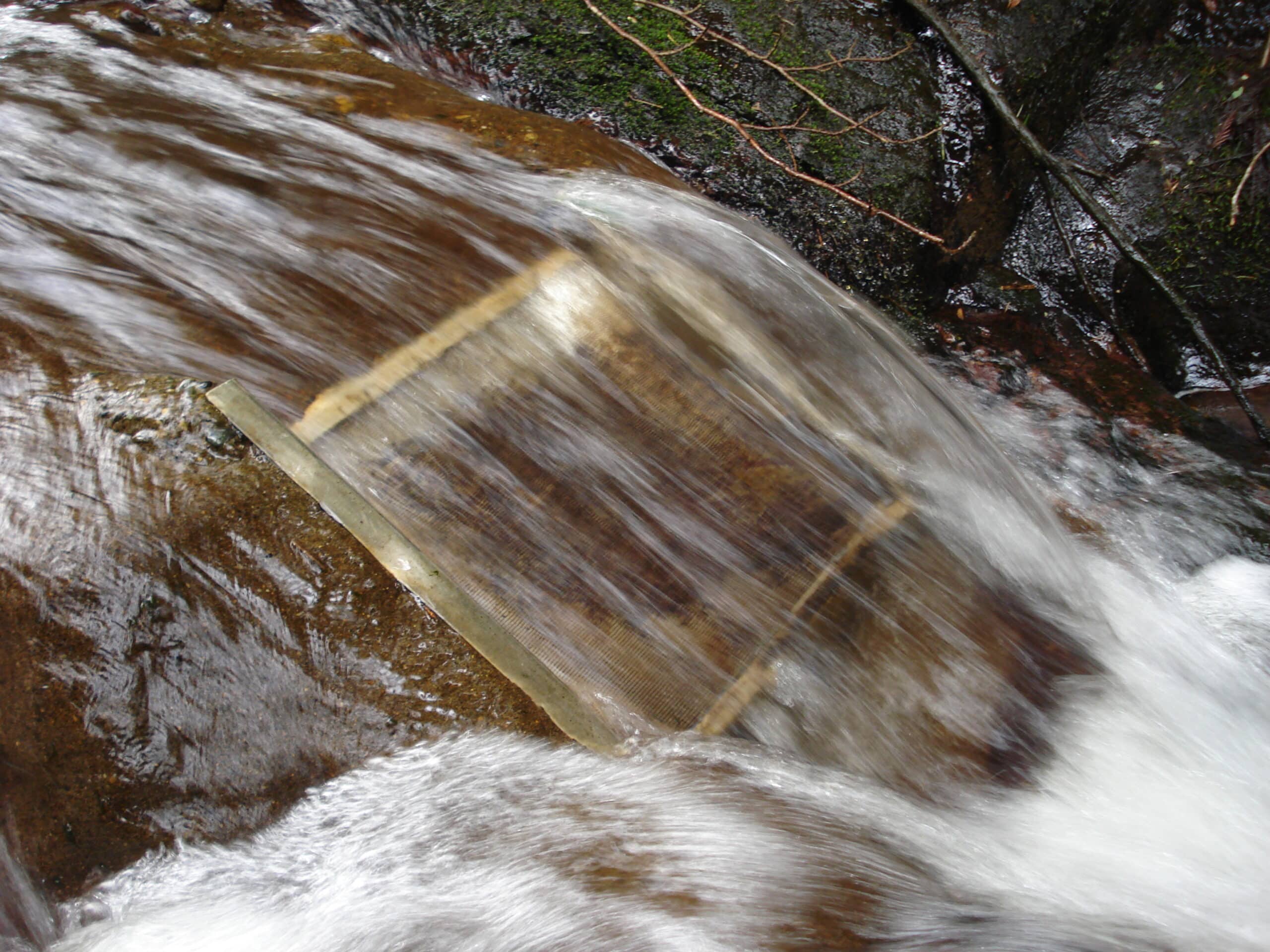 A micro-hydro intake and penstock temporarily divert a portion of the water flow and carry it to the location of the turbine.