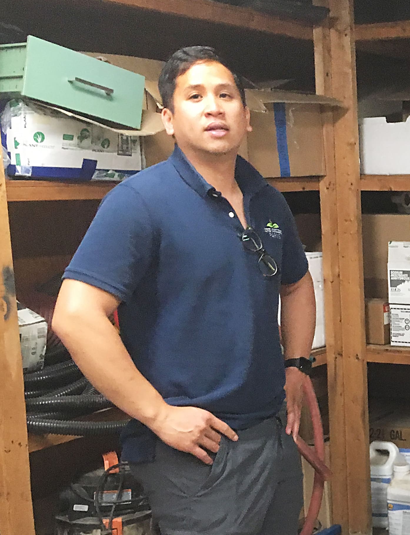 Business Manager Arthur Mulyono stands next to Five College Farms’ collection of organic amendments and control methods.