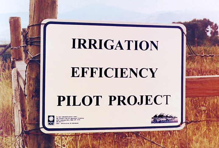 a sign on a fence post reading 