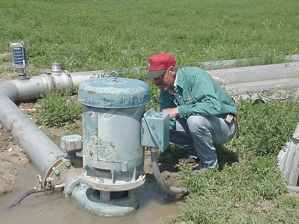 man squatting to assess irrigation system
