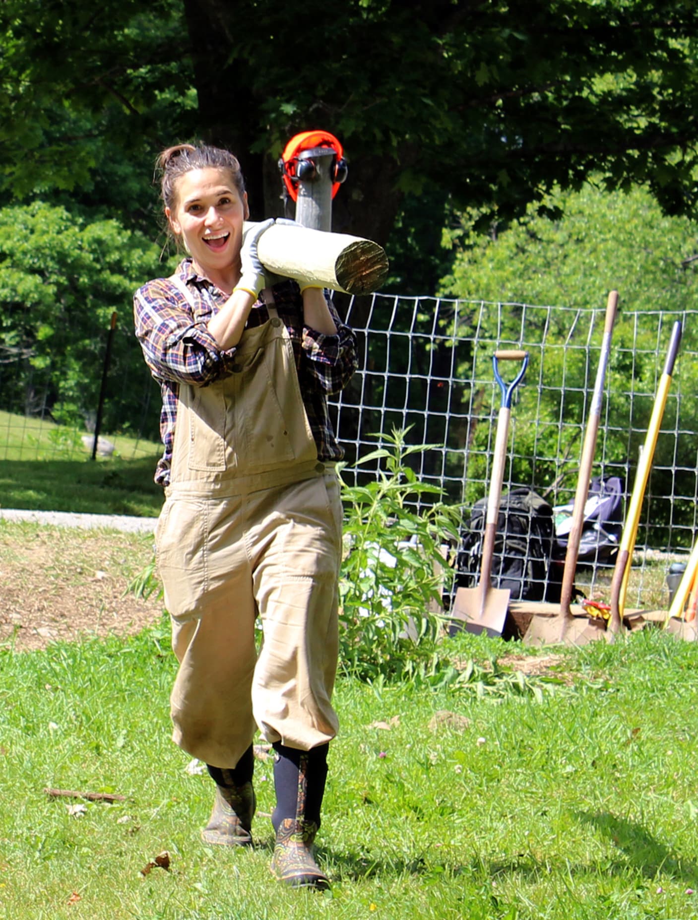 woman lifting a fence post