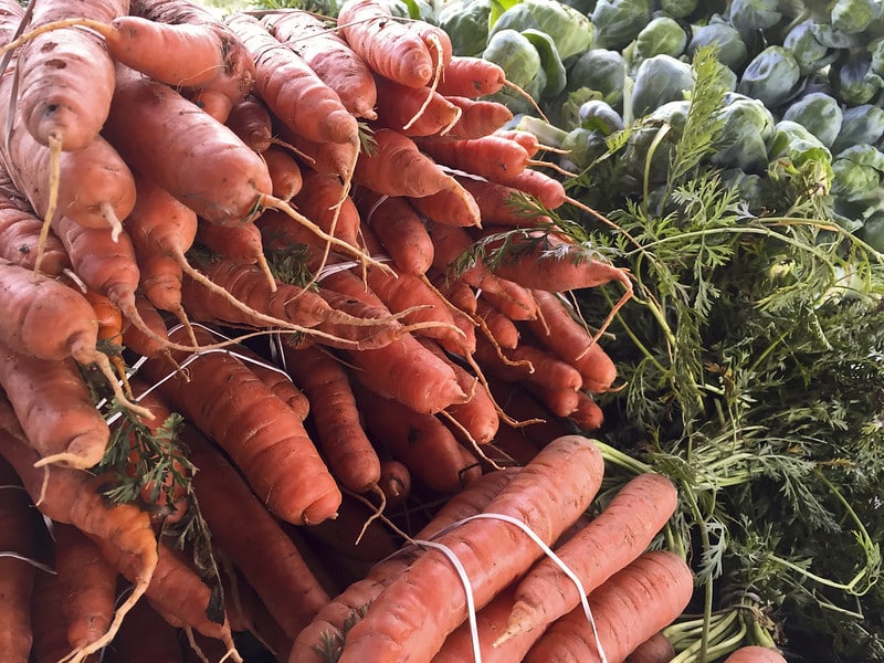 bundled carrots and Brussels sprouts on display