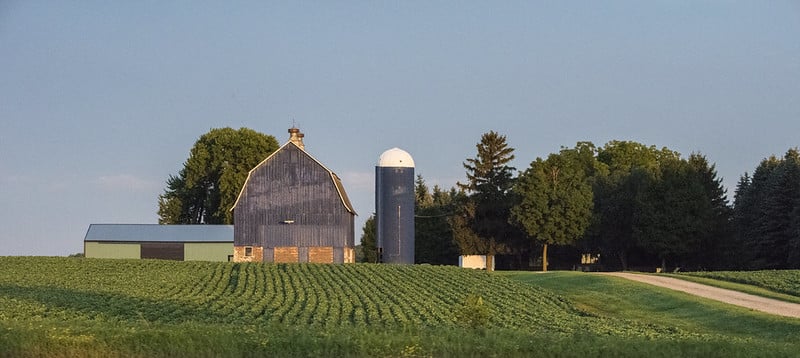 cropland and farm buildings including barn and silos in distance