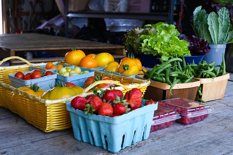 assorted vegetables and fruits in containers on a table