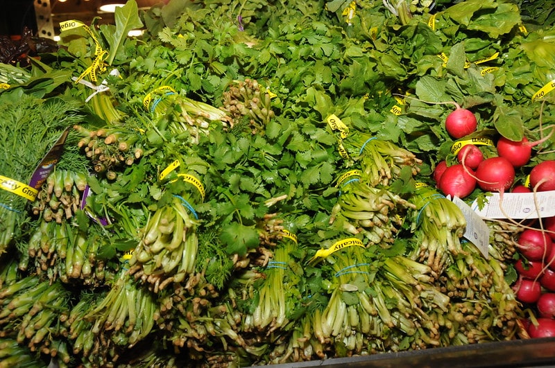 bundles of fresh produce stacked at market