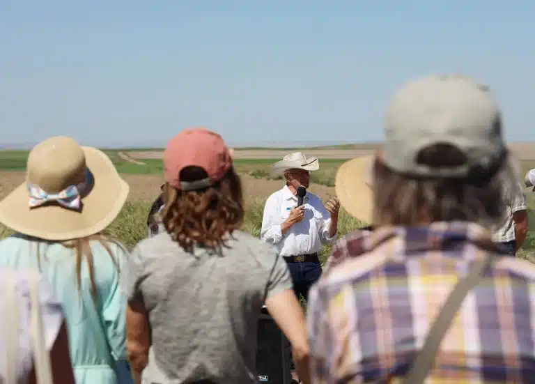 a person addresses a crowd in a field