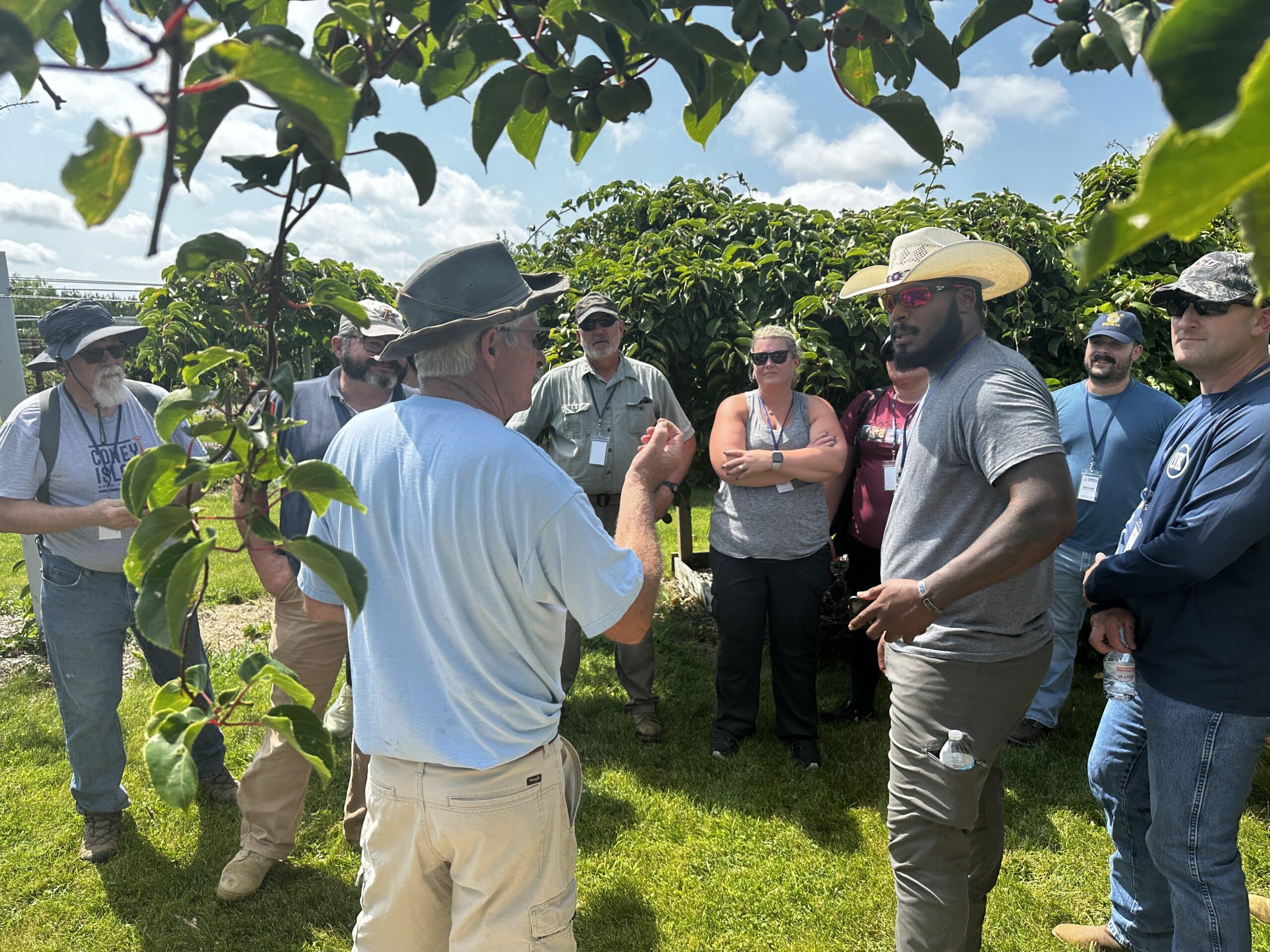 group of people standing among fruit trees