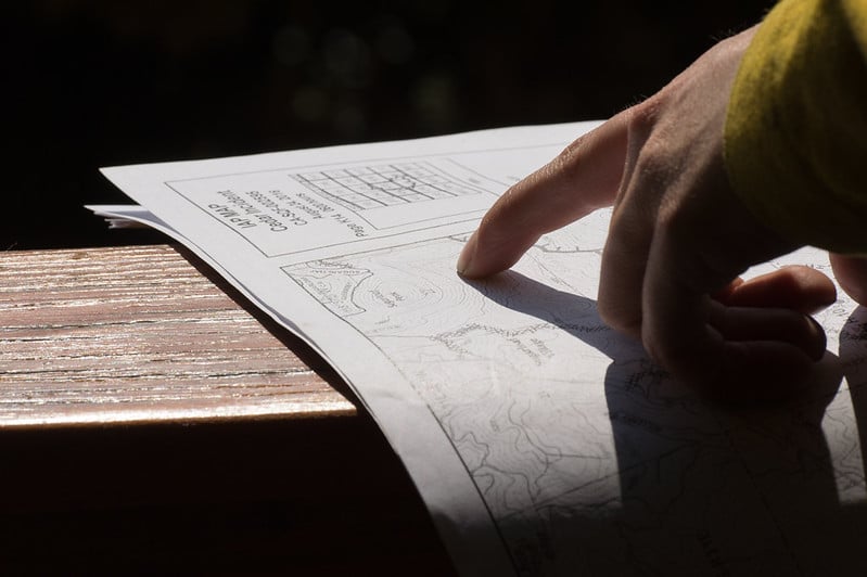 mano con un dedo señalando un mapa sobre una mesa
