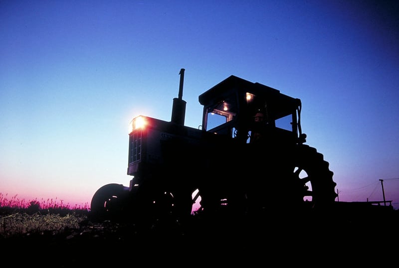 sunrise behind tractor in silhouette