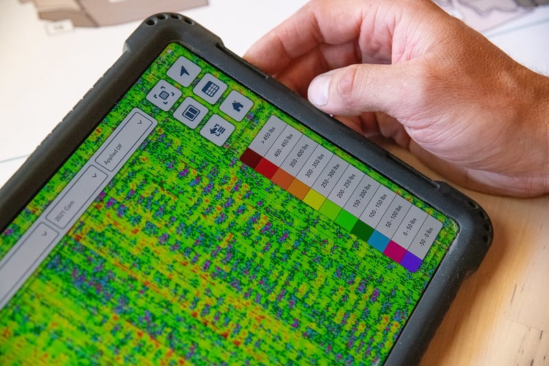 A hand with a tablet displaying color graphics