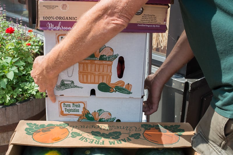 hombres apilando cajas de productos orgánicos